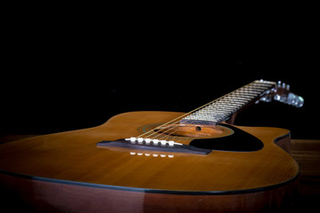 Fototapeta premium acoustic guitar detail on black background