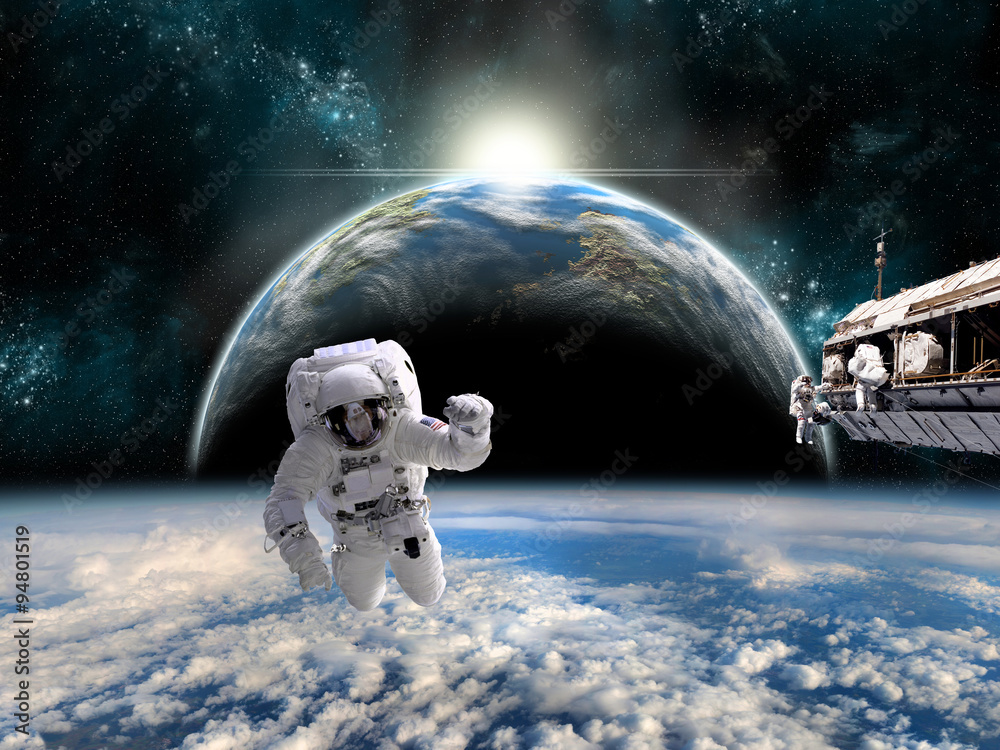 Wall mural a team of astronauts work on a space station - elements of this image furnished by nasa.