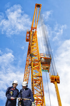 building workers and giant construction crane