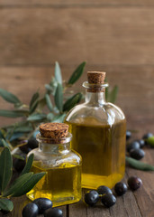 Olive oil and olives on wood background