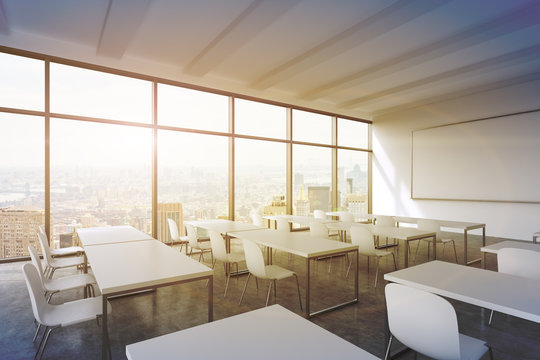 A modern panoramic classroom with New York view. White tables and white chairs. 3D rendering. Sunset. Toned image.