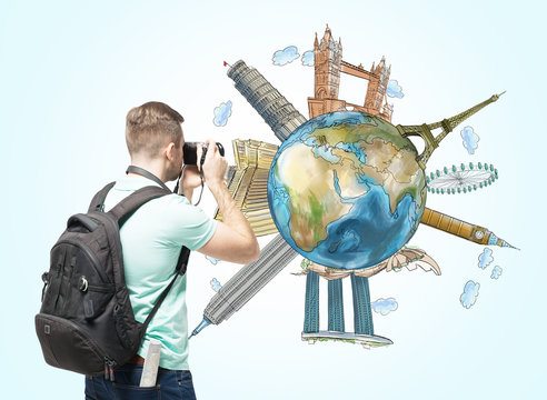 A tourist shoots the globe with sketched famous places. Light blue background. Elements of this image furnished by NASA.