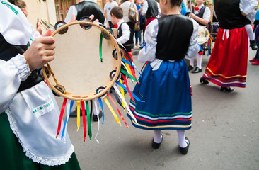 Girl with a typical regional dress playing a colored tambourine during a folkloristic show in Sicily - obrazy, fototapety, plakaty