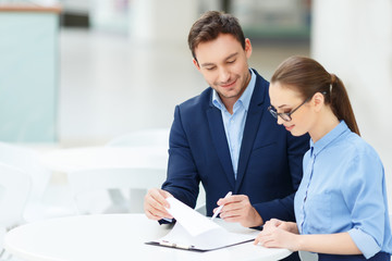 Nice-looking colleagues doing office paperwork