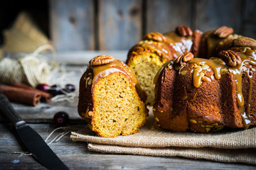 Homemade autumn cake with nuts and caramel on wooden background