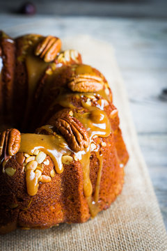 Homemade autumn cake with nuts and caramel on wooden background