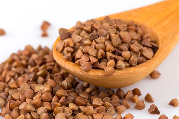 Uncooked buckwheat on wooden spoon