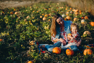 mother and daughter on a field with pumpkins