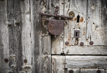 ancient old wooden door with a rusty padlock