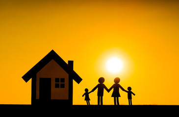 Paper cut of family and a house with sunset background / Family Life Insurance / Protecting family / Family concepts