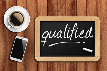 coffee, phone  and chalkboard with  word qualified