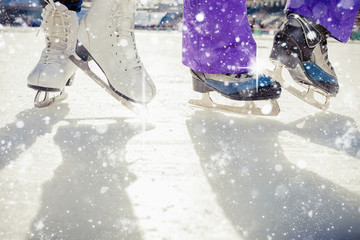 Pair is placed on ice skating. It is snowing outside - obrazy, fototapety, plakaty