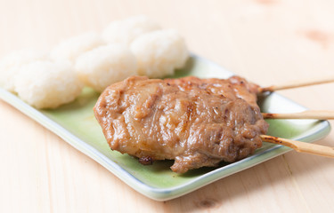 grilled pork and sticky rice on wood background