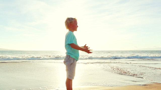 Young Boy Playing Football at the Beach at Sunset. Learning to Catch a Football. Summer Fun Vacation.