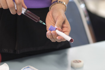 Closeup of nurse's hands taking a blood sample