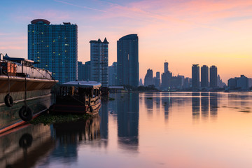 Naklejka premium Bangkok city sunrise view with reflection in river (Chao Phraya river), Bangkok cityscape , long exposure photograph.