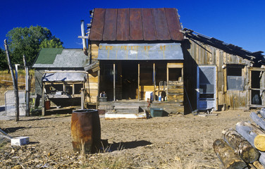 Old ramshackle dwelling with oil drum in dirt yard