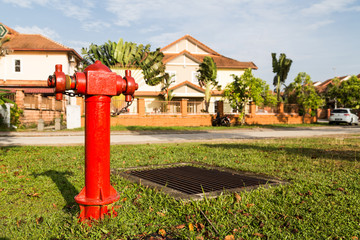 Fototapeta na wymiar Red fire hydrant at strategic residential ready for emergency