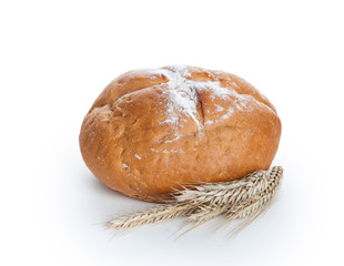 Homemade whole round bread and stalks of wheat