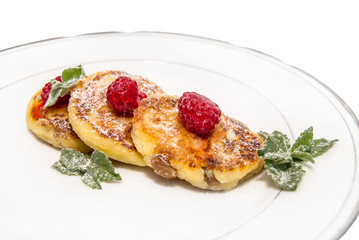 cheese fritters with raspberries on a plate isolated on white ba