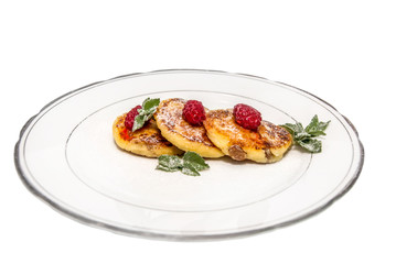 cheese fritters with raspberries on a plate isolated on white ba