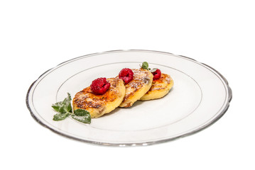cheese fritters with raspberries on a plate isolated on white ba