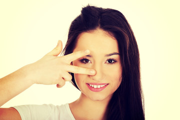 Young woman showing victory sign.