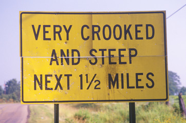 A sign that reads ÒVery crooked and steep next 1 1/2 milesÓ