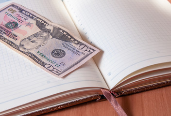 Fifty American dollars and Notepad on wooden table