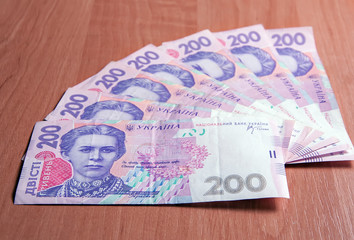 Ukrainian banknotes for two hundred hryvnias on a wooden table