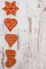 Fresh baked decorated gingerbread on old wooden background, christmas time