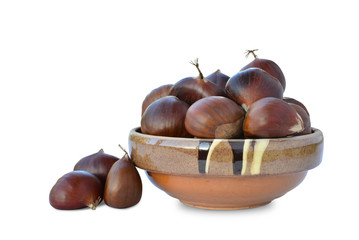 Sweet chestnuts (Castanea sativa) in earthenware bowl isolated on white