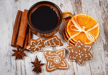 Fresh gingerbread, cup of coffee and spices on old wooden background, christmas time