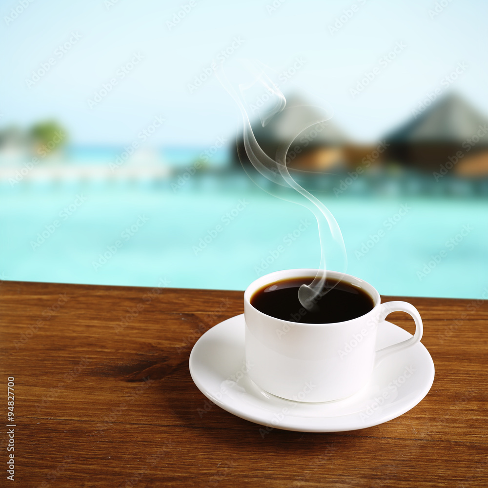 Poster Cup of coffee on table on sea background