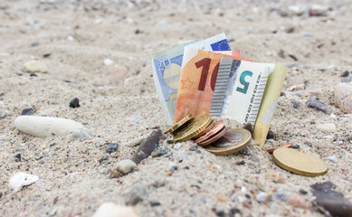money  / Coins, Bills, stones and shells in the sand 