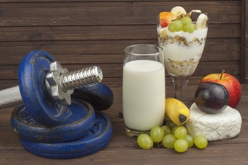 Diet for athletes build muscle mass. Protein snack. Dairy products and dumbbells. fresh milk in the...