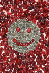 Smiling face mosaic made of cranberry and green pepper