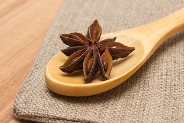 Star anise with wooden spoon on wooden table, seasoning for cooking