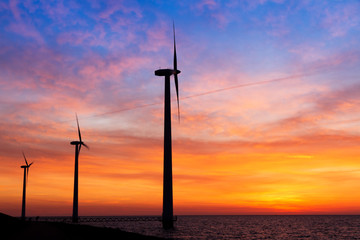 Fototapeta na wymiar Beautiful sunset at the dike with wind turbines at the Markermeer in the Netherlands 