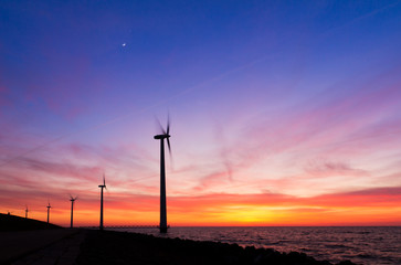 Fototapeta na wymiar Beautiful sunset at the dike with wind turbines at the Markermeer in the Netherlands 