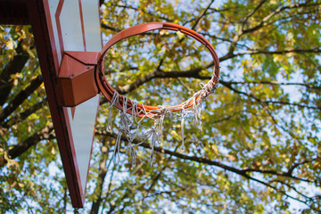 Basketball board and hoop in the park. Orange-white color.