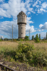 Fototapeta na wymiar Abandoned water tower near old railway track