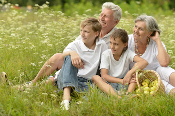 Family on  summer grass with apples