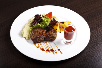 dish with meat, potatoes and herbs on a white plate