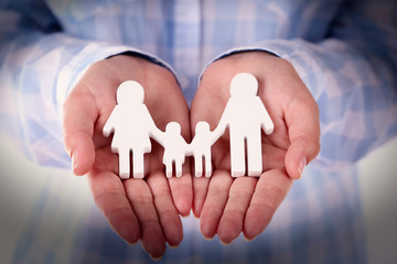 Female hands holding toy family, closeup