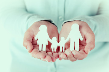 Female hands holding toy family, closeup