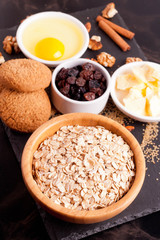 butter, cereal and ingredients for baking cookies on black table