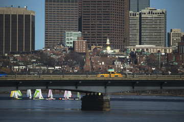 Yellow Taxi drives across Harvard Bridge over Charles River with Colorful sailboats, Boston,...