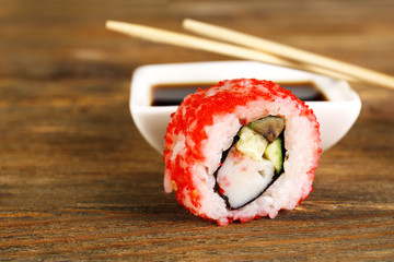 Roll with sauce and sticks on wooden table close up