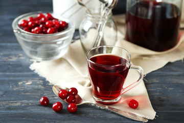 Sweet homemade cherry juice on table, on color wooden background